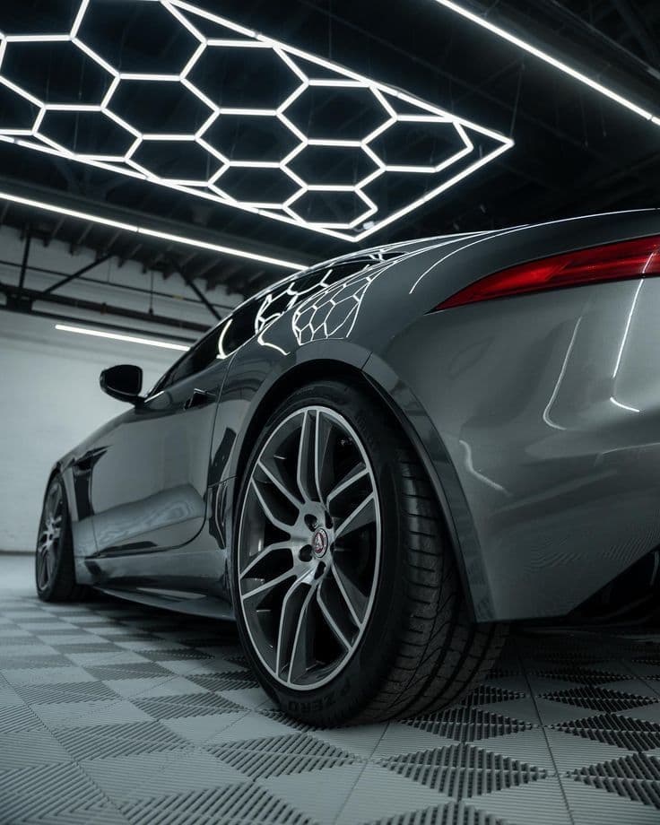 Traseira de carro esportivo com pintura espelhada refletindo iluminação hexagonal